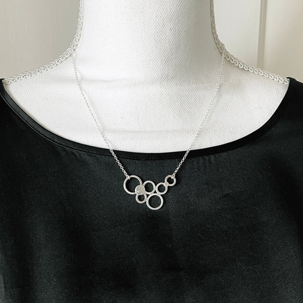 Silver multi circle necklace with a diamond by eko jewelry design, Delicia on model