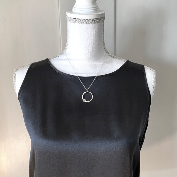Silver circle necklace with a gemstone by eko jewelry design, Thebe on model